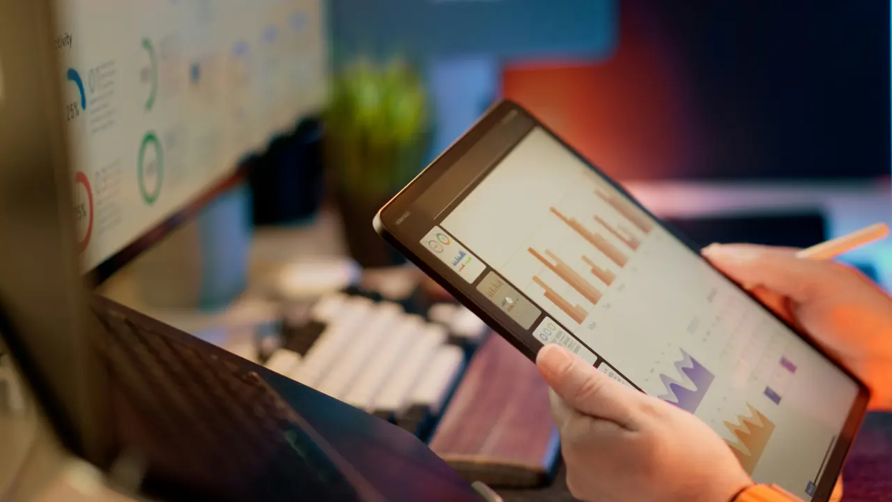 Marketing analyst reviewing campaign reports at a laptop.