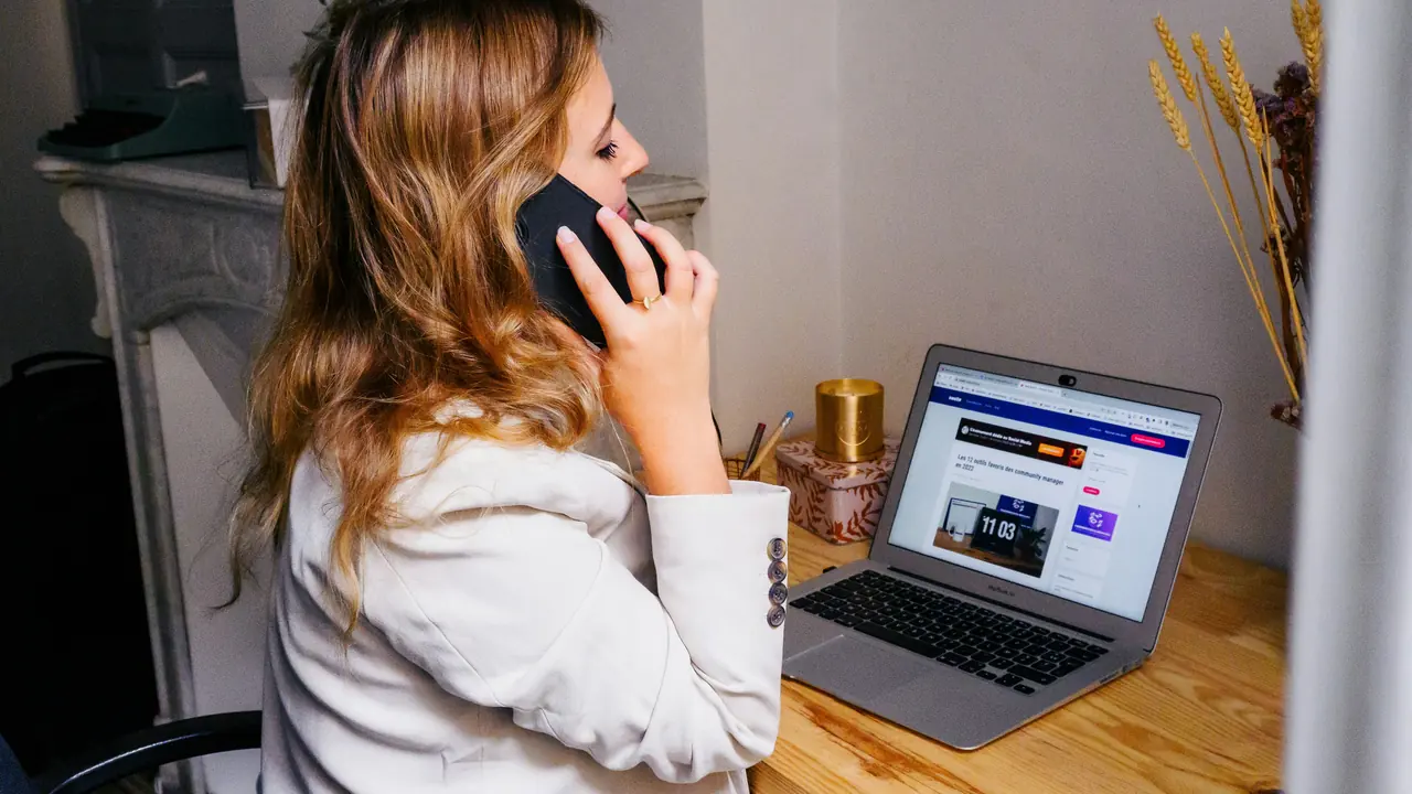 Sales professional reviewing follow-up notes beside a laptop.